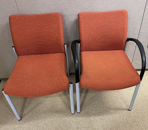Two clay-colored cushioned chairs with light gray metal legs, one with arms and one without.